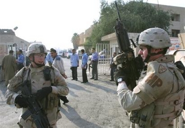Two reserve U.S. Army Military Policemen secure the area outside Al Kindi hospital where the injured were taken in Baghdad, Iraq, Tuesday Dec. 6, 2005, after two suicide bombers strapped with explosives blew themselves up at Baghdad's police academy 