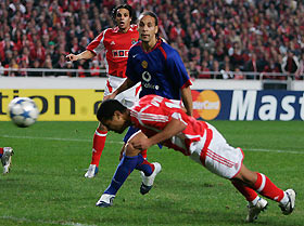 Rio Ferdinand (C) and Benfica's Nuno Gomes (L) watch as Geovanni scores a header during their Champions League Group D soccer match at the Luz Stadium in Lisbon December 7, 2005.