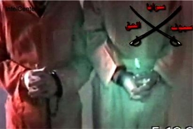 This still image made from video and released Wednesday, Dec. 7, 2005 by IntelCenter, a government contractor that does support work for the U.S. intelligence community, shows the chained hands of hostages Briton Norman Kember, left, and American Tom Fox.