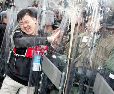 A South Korean worker fights with Hong Kong riot police as protesters try to march toward the main venue for the World Trade Organisation (WTO) meeting in Hong Kong December 13, 2005. Riot police used pepper spray to hold back anti-globalisation protesters in Hong Kong on Tuesday as a meeting of ministers from WTO nations got underway at a convention centre about 1 km away.