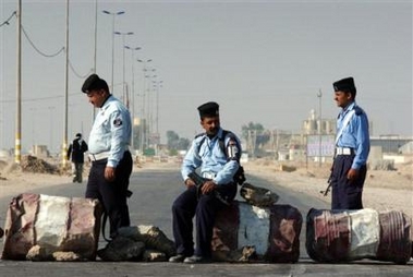 Iraqi policemen block a street in Najaf, Iraq, Wednesday Dec. 14, 2005.