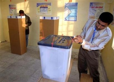 An electoral independent commission worker examines a ballot box as voting begins during Iraq's historical parliamentary elections in the Iraqi city of Basra, 549km (341 miles) south of Baghdad, December 15, 2005.