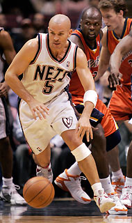 New Jersey Nets guard Jason Kidd (5) heads up court after grabbing a loose ball in front of Golden State Warriors center Adonal Foyle (C) in the second quarter of their NBA game in East Rutherford, New Jersey, December 18, 2005. Nets won 118-90 as Kidd scored 24 points.