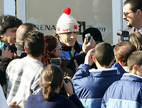 Fernando Alonso of Spain (C) is surrounded by fans in the paddock during a free practice session at the Jerez race track in southern Spain December 16, 2005.