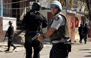 A Canadian U.N. policeman patrols a street in the volatile neighbourhood of Bel-Air in Port-Au-Prince, Haiti in this November 26, 2004 file photo.