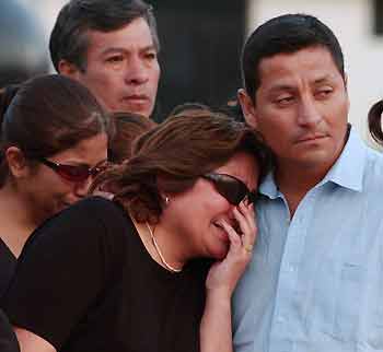 Relatives of Peruvian police officers killed by rebels in the Huanuco region cry as the coffins of the victims arrive at the airport in Lima December 21, 2005. Peruvian rebels killed eight policemen in an ambush in the country's cocaine-producing central jungle, the second deadly attack this month, the Interior Ministry said on Wednesday. Rebels attacked a police vehicle on a routine patrol in the remote Huanuco region on Tuesday night. 