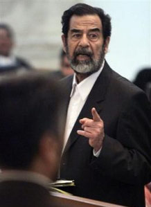 Saddam Hussein again grabbed center stage at his mass murder trial Wednesday, suddenly standing up and surprising the courtroom with claims that he and other defendants were "beaten by Americans." 