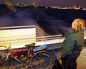 A commuter, who cycled into the city in the morning, takes a water taxi back to Brooklyn during the evening rush hour in New York December 21, 2005.