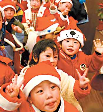 A group of children dressed in Santa Claus outfits pose in a shopping mall in Shanghai on Friday. Led by their teachers, these children from a kindergarten in Shanghai went to the shopping mall to take part in a Christmas party. (REUTERS)