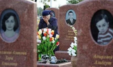 A relative of the Aslan and Soslan Beroev brothers, who died in last years school siege in Beslan, reacts at the cemetery in Beslan August 30, 2005.