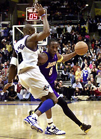 Kobe Bryant (R) drives around Washington Wizards' Antawn Jamison during the second half of their NBA game in Washington December 26, 2005. 