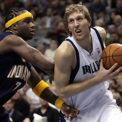 Mavericks forward Dirk Nowitzki (R) drives against Indiana Pacers center Jermaine O'Neal during second half action in Dallas, Texas December 26, 2005. The Mavericks defeated the Pacers 102-80.