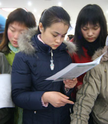 Job-seekers look at employment information at a job market in Xingtai, North China's Hebei Province December 26, 2005. [newsphoto]