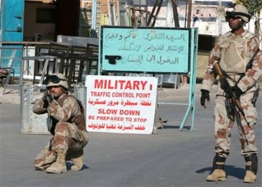 An Iraqi soldier trains his rifle at a checkpoint close to a prison where an inmate grabbed an assault rifle from a guard and opened fire, killing eight people, in Baghdad, Iraq, Wednesday Dec. 28, 2005, the Interior Ministry said.