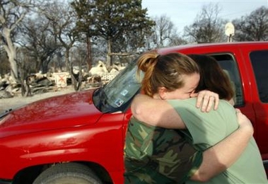 Kristin Hunter, left, hugs her mother, Terri Hunter, after learning that a neighbor is unaccounted for following a grass fire that swept through the small town of Cross Plains, Texas, Wednesday, Dec. 28, 2005.