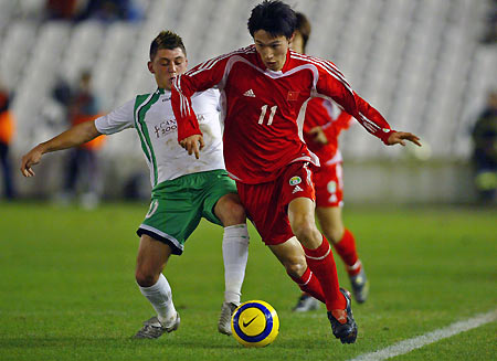 China's Cao fights for the ball with Racing Santander's Valle during their soccer match in northern Spain
