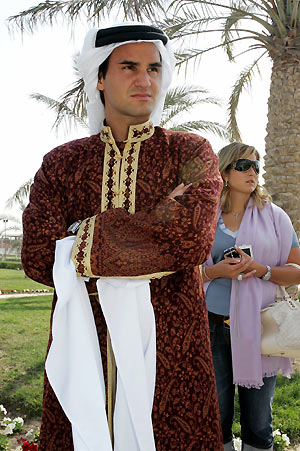 World number one tennis player Roger Federer (L) of Switzerland poses wearing traditional Qatari dress during a desert trip, on the second day of the Qatar Open tennis tournament, in the outskirts of Doha January 3, 2006.