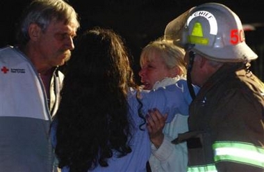 An unidentified family member, second from right, is comforted upon her arrival Tuesday, Jan. 3, 2005 at in Tallmansville, W. Va.