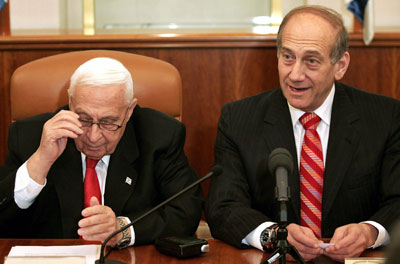 Israeli Prime Minister Ariel Sharon (L) and Deputy Prime Minister Ehud Olmert attend a ceremony completing the sale of Bank Leumi to a private U.S. investment group in Sharon's office in Jerusalem January 4, 2006. Sharon suffered a "significant stroke" on Wednesday and was under sedation while undergoing hospital treatment, his doctor, Shlomo Mor-Yosef, told reporters. Cabinet secretary Israel Maimon said Olmert would assume Sharon's powers.