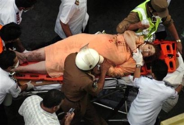 An injured woman is taken away by rescuers at the scene of a building collapse in Mecca, Saudi Arabia Thursday, Jan. 5, 2006.
