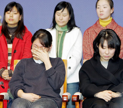 Members of South Korean stem-cell scientist Hwang Woo-suk's research team weep as Hwang (unseen) speaks at a news conference in Seoul January 12, 2006. Disgraced South Korean scientist Hwang apologised on Thursday for wrongdoing at his laboratory, but said his team may have been the victim of a conspiracy trying to discredit them.
