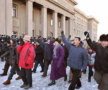 Mongolians march past the heavily secured parliament during a demonstration in the Mongolian capital Ulan Bator January 16, 2006.