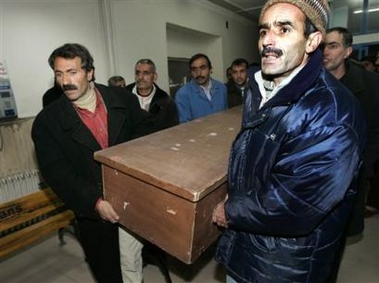Mehmet Ozcan, left, is helped by to carry the coffin of his daughter Fatma Ozcan, 12, the fourth suspected death from bird flu, in the hospital of Van, eastern Turkey, Sunday, Jan. 15, 2006.