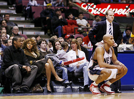 Jay-Z and Beyonce (L) sit court-side and watch the New Jersey Nets play the 