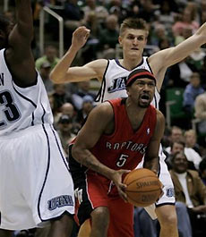 Toronto Raptors guard Jalen Rose (5) slips between Utah Jazz guard Devin Brown, left, and forward Andrei Kirilenko, of Russia, during the second quarter of their NBA game Tuesday, Jan. 17, 2006, in Salt Lake City.