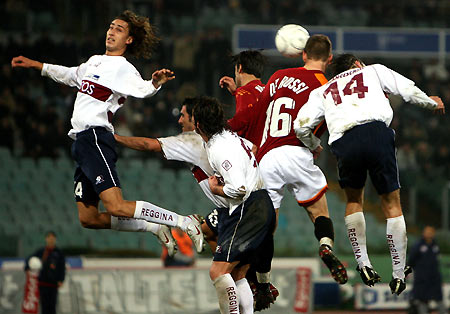 Reggina's Simone Missiroli (L) and Ivan Franceschini (R) jump for the ball with AS Roma's Daniele De Rossi (2nd R) during their Italian Serie A soccer match in Rome's Olympic stadium January 18, 2006. Roma won the match 3-1. [Reuters]
