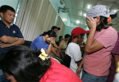 Relatives cry as they identify their loved ones among those who died during a stampede in suburban Pasig, east of Manila, Saturday, Feb. 4, 2006. 