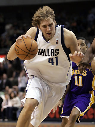 Dallas Mavericks forward Dirk Nowitzki (L) drives the lane past Los Angeles Lakers guard Devon Green (R) during second half NBA action in Dallas, Texas February 7, 2006. The Mavericks defeated the Lakers 102-87 to push their winning streak to 12 games.