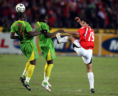 Egypt's Captain Ahmed Hassan (C) and Senegal's Frederic Mendy (L) are airborn as they fight for the ball during their semi-finals African Nations Cup soccer match in Cairo, Egypt, February 7, 2006. [Reuters]