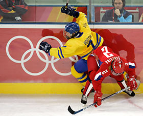 Sweden's Maria Rooth (L) is checked into the boards by Russia's Maria Barykina during the second period of their ice hockey game at the Torino 2006 Winter Olympic Games in Turin, Italy February 11, 2006.