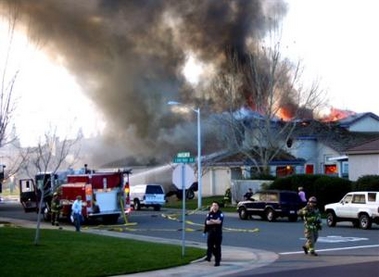 Smoke and flames rise from a home struck by a single engine plane in Roseville, Calif., Sunday, Feb. 12, 2006.