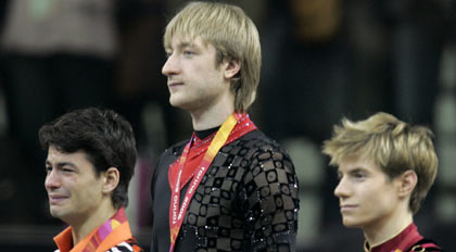 Gold medal winner Evgeni Plushenko from Russia (C), silver medal winner Stephane Lambiel from Switzerland and bronze medal winner Jeffrey Buttle (R) from Canada pose on the podium after men's figure skating at the Torino 2006 Winter Olympic Games in Turin, Italy February 16, 2006.