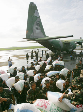 Philippines soldiers unload sacks of rice from a military plane for mudslide victims at the Tacloban airport in central Philippines February 18, 2006. Hundreds of people were feared dead in the remote farming village of Guinsaugon, near Saint Bernard town in southern Leyte province, after mudslides triggered by heavy rains buried houses and an elementary school packed with children on Friday, officials and witnesses said. 