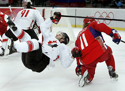 Russia's Darius Kasparaitis (R) upends Canada's Simon Gagne during in their men's quarter final ice hockey game at the Torino 2006 Winter Olympic Games in Turin, Italy, February 22, 2006. [Reuters]