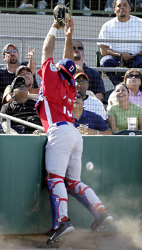 Dominican Republic National Team catcher Juan Brito leaps for and misses a foul ball on the net, hit by the Houston Astros Raul Chavez, during their exhibition game at the Houston Astros spring training camp in Kissimmee, Florida, March 5, 2006. The Dominican Republic won the game 12-8 and will begin play in the World Baseball Classic against Venezuela in Kissimmee on March 7. [Reuters]