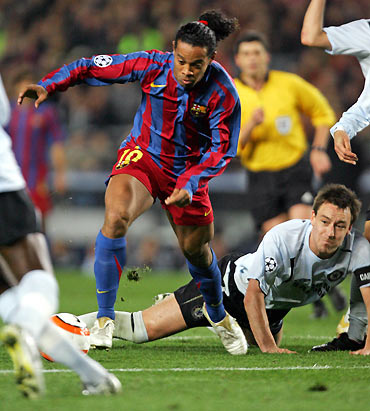 Barcelona's Ronaldinho (L) of Brazil dribbles past Chelsea's John Terry (bottom R),