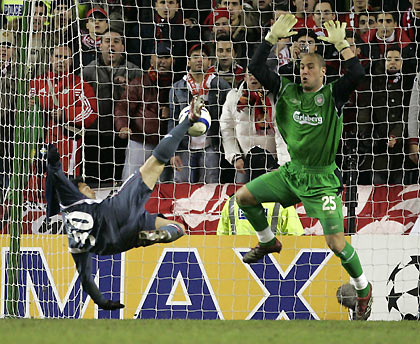 Benfica's Fabrizio Miccoli scores past Liverpool's Jose Reina (R) during a Champions League first knockout round second leg soccer match at Anfield in Liverpool, northern England, March 8, 2006. Benfica won the match 2-0 and the round 3-0 on aggregate.