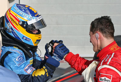 Winner of the Bahrain Formula One Grand Prix Renault's Fernando Alonso of Spain (L) is congratulated by Ferrari's Michael Schumacher of Germany at the end of the race at the Sakhir racetrack in Manama March 12, 2006.