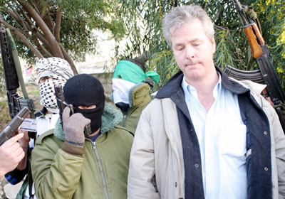 Palestinian militants stand with U.S. citizen Douglas Johnson, an English teacher at the Arab American University, moments after he was kidnapped near the West Bank town of Jenin March 14, 2006. Johnson, kidnapped by Palestinian gunmen in the West Bank on Tuesday has been freed, militants and the school that employed him said.