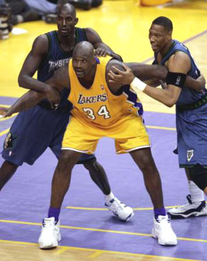 Shaquille O'Neal being defended by two Timberwolves players in the post.