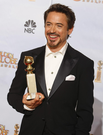 Robert Downey Jr. poses with his award for Best Performance by an Actor in 