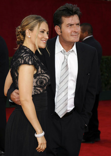 Sheen charged with assaulting wife; they hug in court