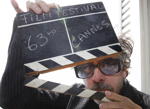 Tim Burton holds a film clapper in Cannes