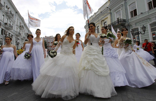 Women in bridal gowns take part in a carnival in Russia