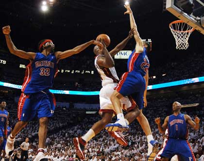 Miami Heat forward Antoine Walker (2L) drives to the basket while being defended by Richard Hamilton (32), Tayshaun Prince (22), and Chauncey Billups (1) of the Detroit Pistons during their NBA Eastern Conference Finals Game 3 playoff match-up in Miami, Florida, May 27, 2006.
