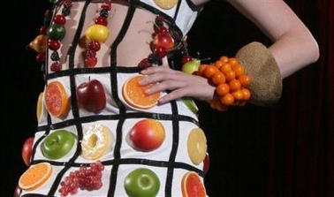 A model dressed in an outfit made of real and imitation fruit walks the runway during a summer salad fashion show at New York's Grand Central Terminal Friday